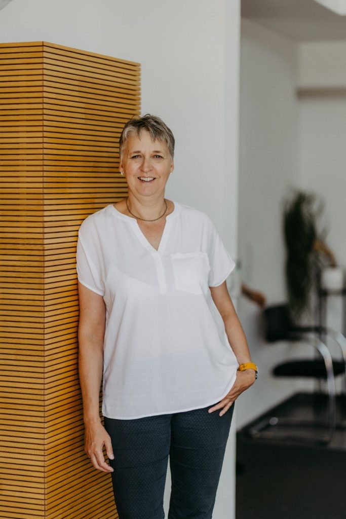 Frau in heller Bluse lächelt